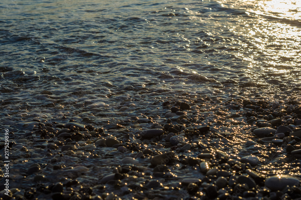 pebble stones on the sea beach, the rolling waves of the sea with foam pebble stones on the sea beach, the rolling waves of the sea with foam