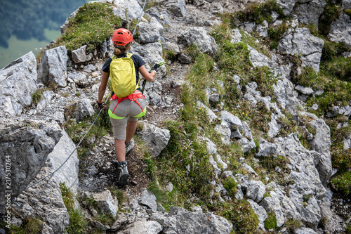 Pretty, female climber on a via ferrata - climbing on a rock in Swiss Alps © lightpoet