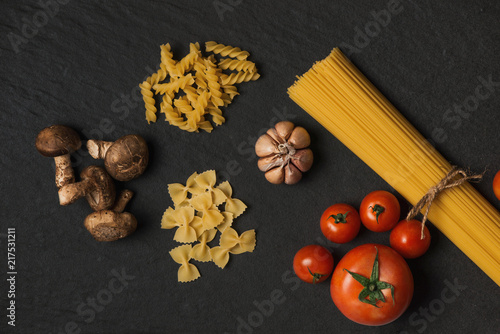 Italian food concept. Pasta ingredients. Cherry-tomatoes, spaghetti pasta, rosemary and spices