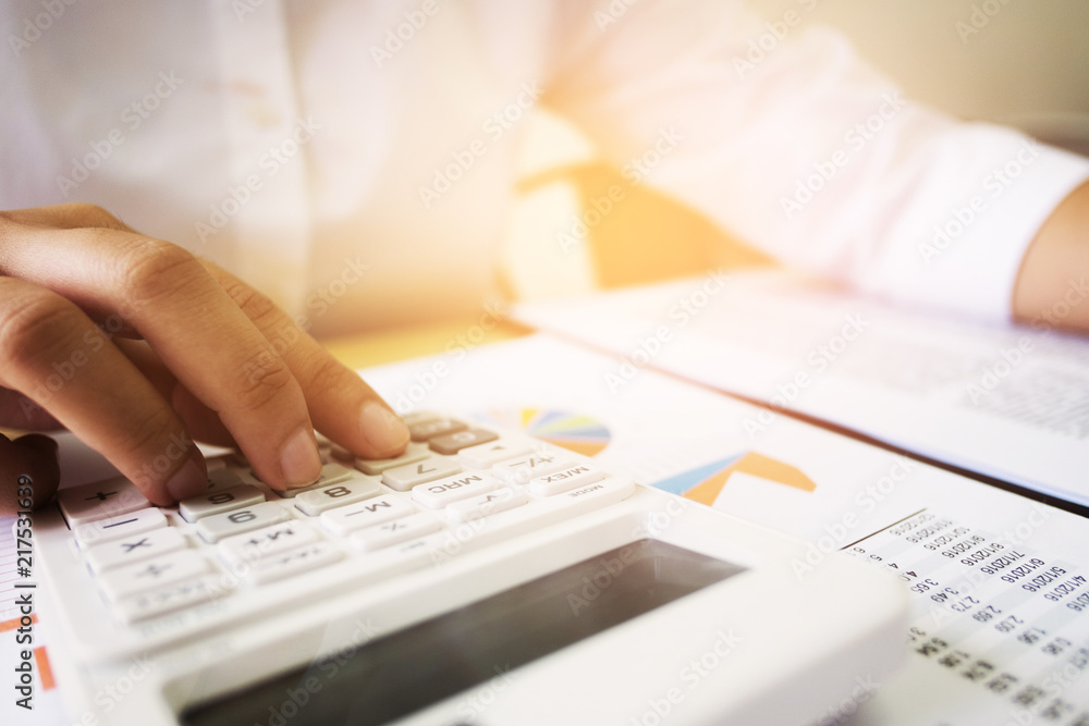 Business woman analysis investment perform data document and calculating a valuation number Business woman analysis investment perform data document and calculating a valuation number