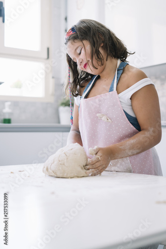 Little girl amassing flour to make bread