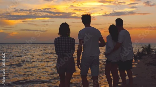 Friends near sea at sunset. Slow-motion shooting.