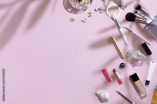 Flat lay and top view of make up products and cosmetics set on pink backgroun...