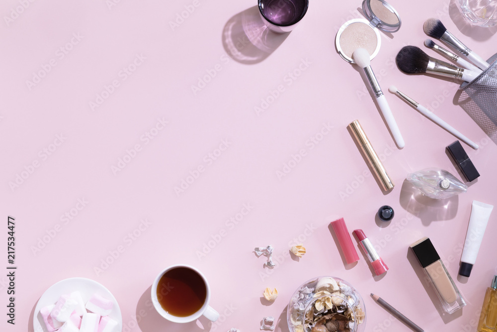 Makeup products and coffee or tea cup on pink color background with hard light and shadows, flat lay and top view Makeup products and coffee or tea cup on pink color background with hard light and shadows, flat lay and top view