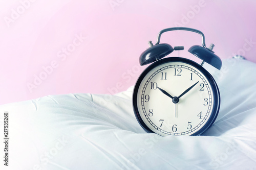 Alarm clock on the pillows. Advertizing concept, copy space