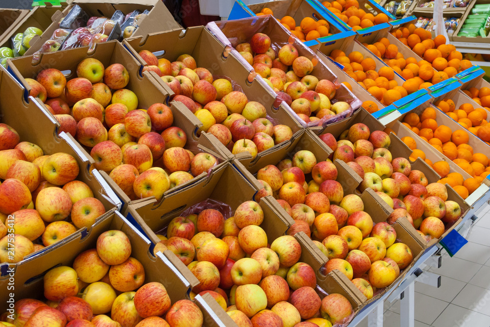 A rows of cartons boxes with apples and oranges in supermarket A rows of cartons boxes with apples and oranges in supermarket