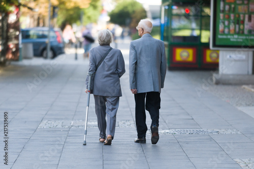 starsze osoby spacerują chodnikiem
