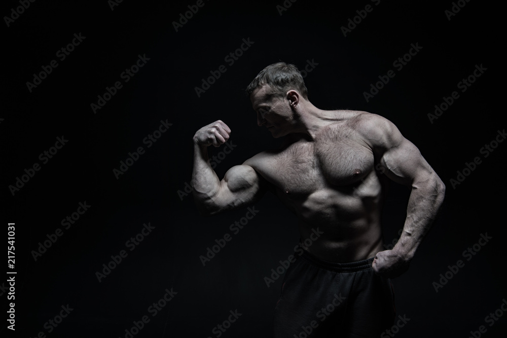 Perfect body. Man bodybuilder posing with tense muscles on black background. Bodybuilder achieved best shape for muscles. Ready for championship. Bodybuilder perfect muscular body, copy space