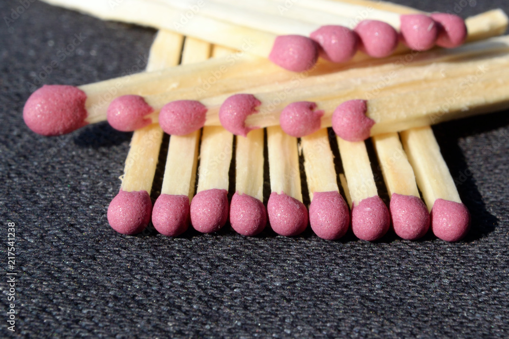Matches in a row against a dark background Matches in a row against a dark background