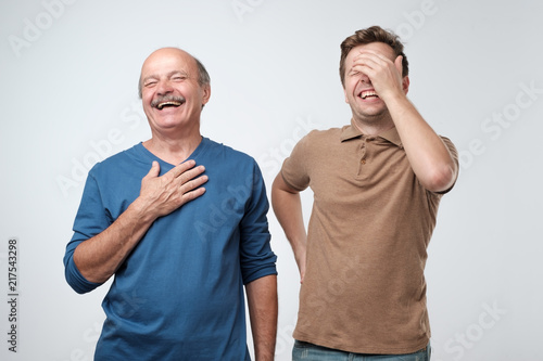 Foto Two friends in casual colorful wear standing and laughing together