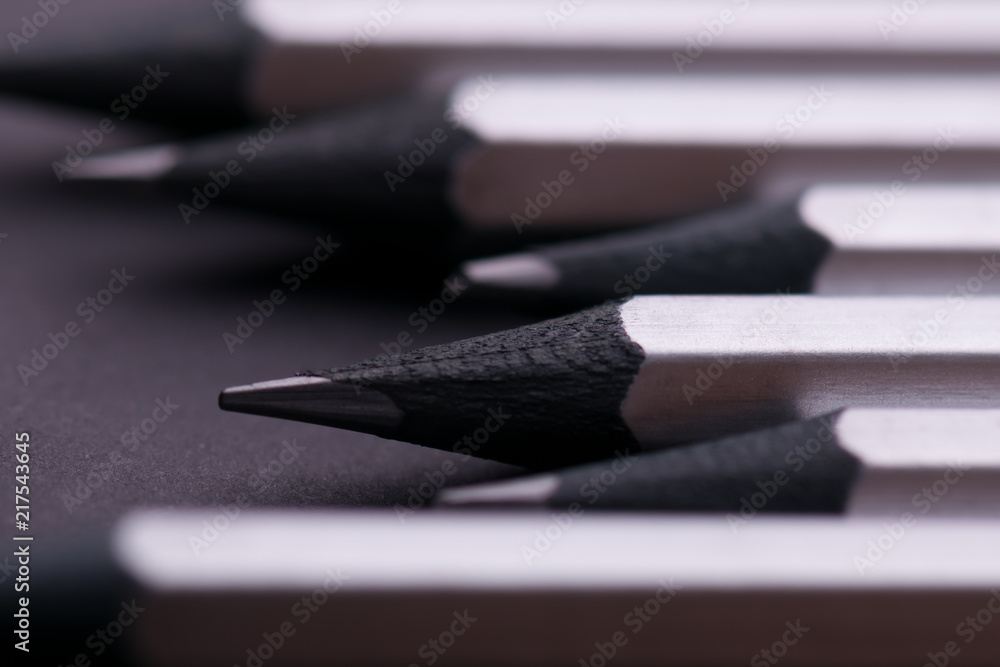 Fototapeta premium Gray sharpened pencils close-up on a dark background.