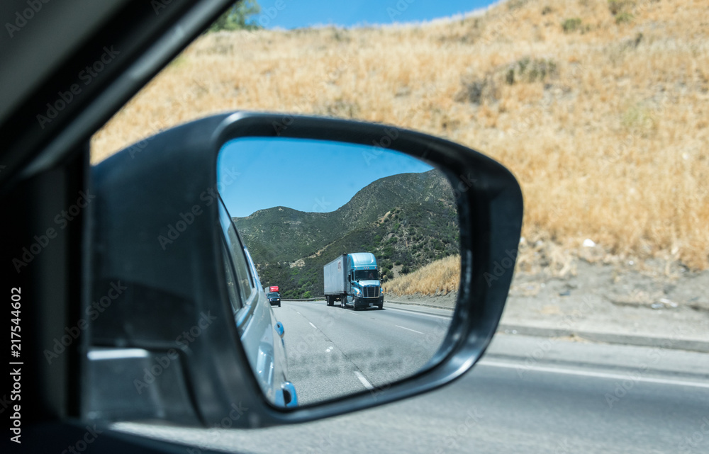 Freight traffic in the USA. High-speed highway and cars and Los Angeles County. View in the side mirror Freight traffic in the USA. High-speed highway and cars and Los Angeles County. View in the side mirror