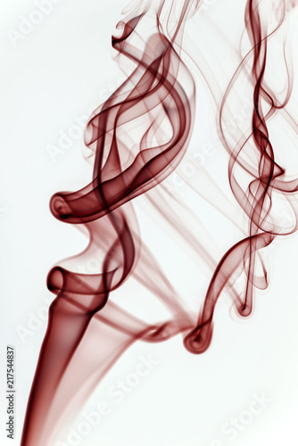 Red smoke on a white background and texture. Isolated colorful smoke in a studio space. Mystical artwork and shape.