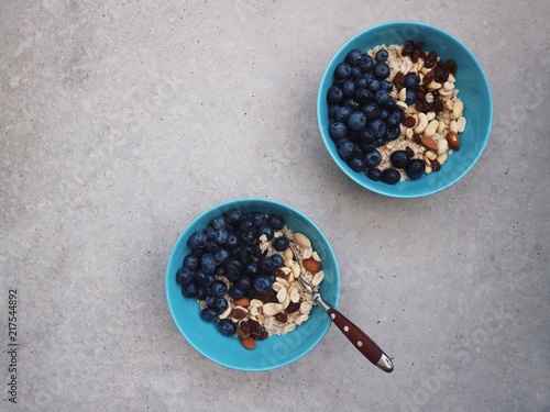 Healthy breakfast in a blue bowl. Oatmeal with blueberries and nut mix. Healthy food concept. Top view, side view. Space for text.