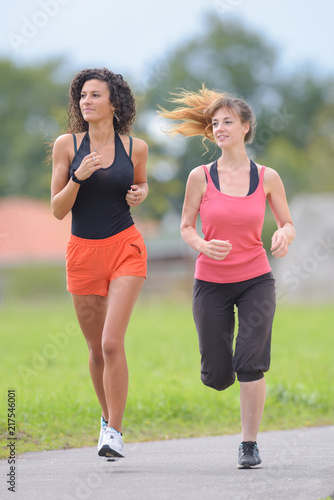 Two women running in park