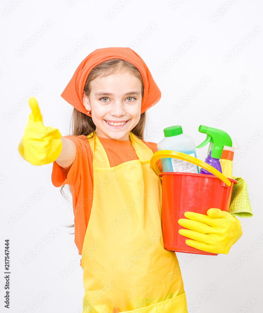 Happy girl with cleaning supplies in bucket standing on white background and showing thumbs up Happy girl with cleaning supplies in bucket standing on white background and showing thumbs up