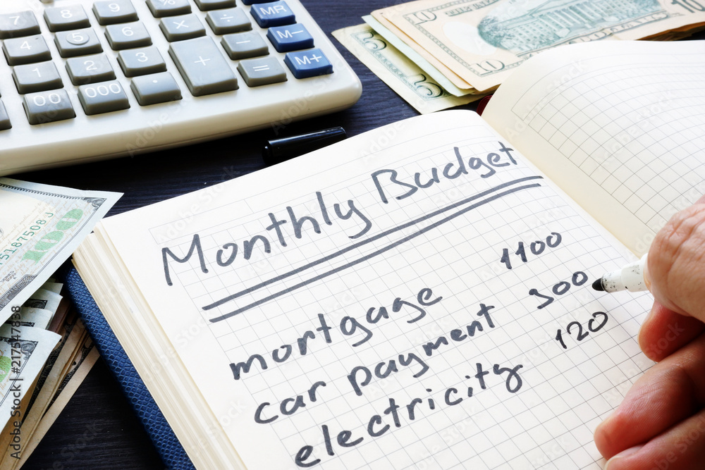 Man is writing Monthly Budget Plan. Home finances.