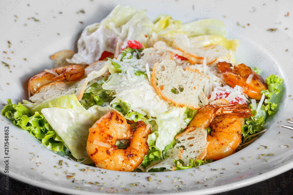 Shrimp salad with parmesan cheese, croutons, tomatoes, mixed greens, lettuce on wooden background. Healthy food Shrimp salad with parmesan cheese, croutons, tomatoes, mixed greens, lettuce on wooden background. Healthy food
