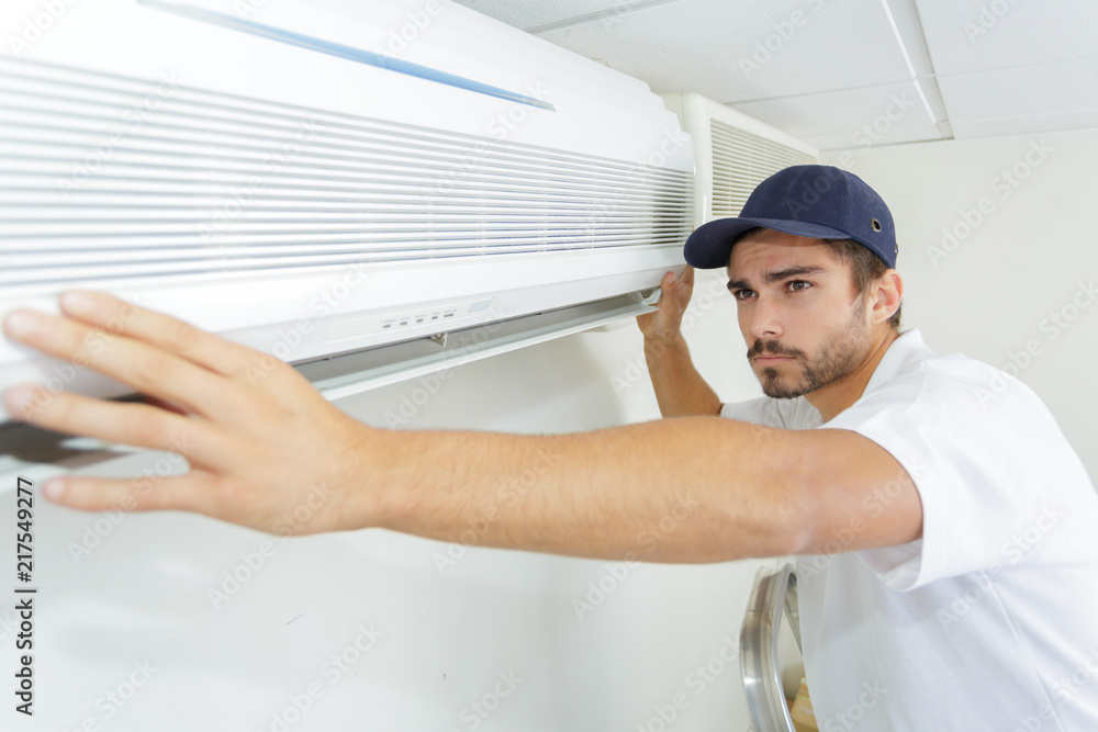 Obraz premium tech guy carefully installing new ac