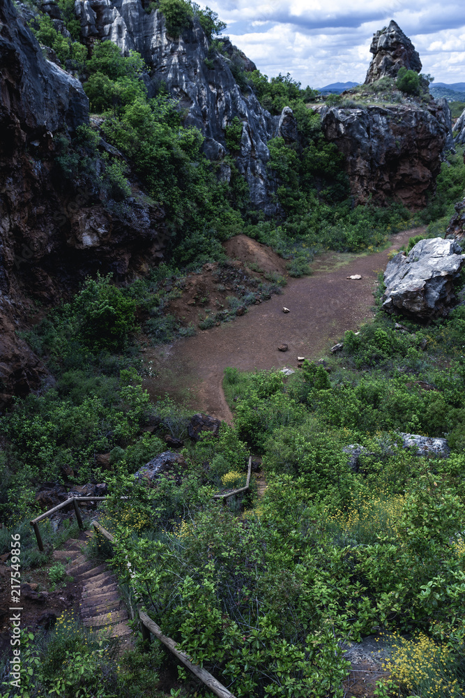 Obraz premium From above small path with wooden steps in mountains covered with green in Cerro del Hierro, Seviile