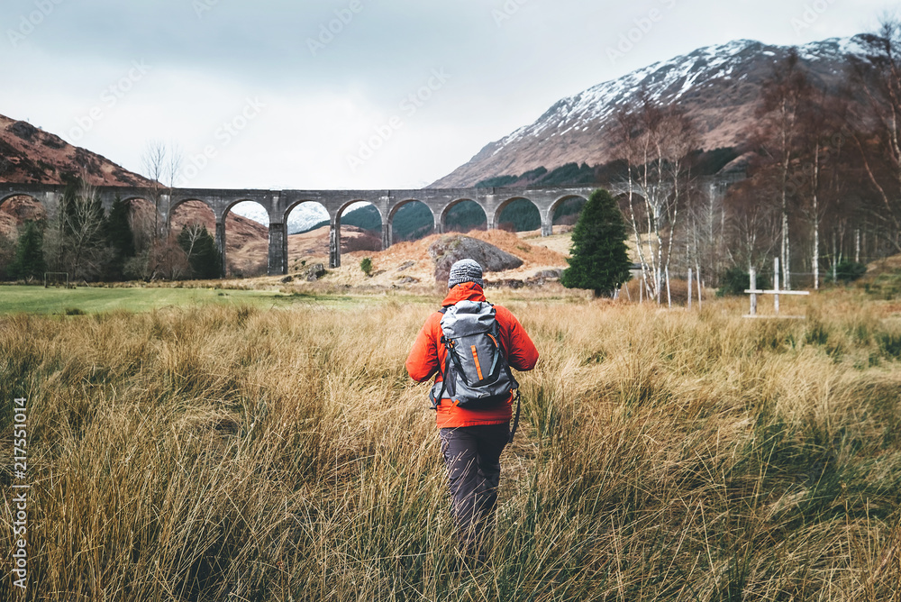 Fototapeta premium Man traveler walks neaar famous Glenfinnan viadukt in Scotland