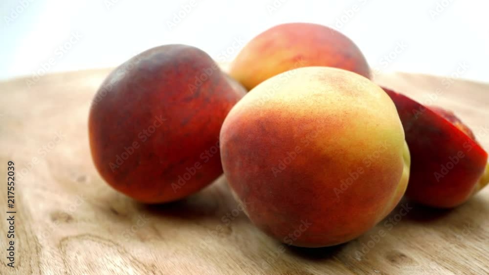 Fresh Peaches rotating on the wooden table. Fruits rotating on the turntable. Isolated on the white background. Close up. 4K Fresh Peaches rotating on the wooden table. Fruits rotating on the turntable. Isolated on the white background. Close up. 4K