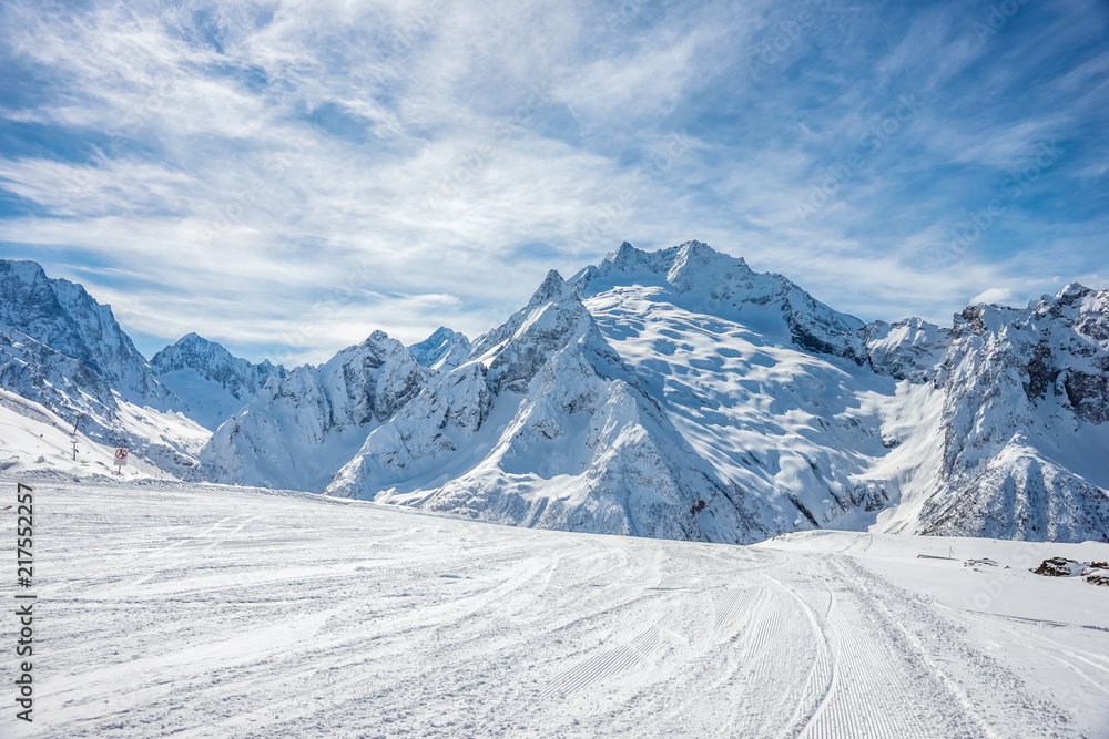 Ski slope, Peak Ine and Mt. Sofrudzhu in winter sunny day. Dombay ski resort, Western Caucasus, Russia.