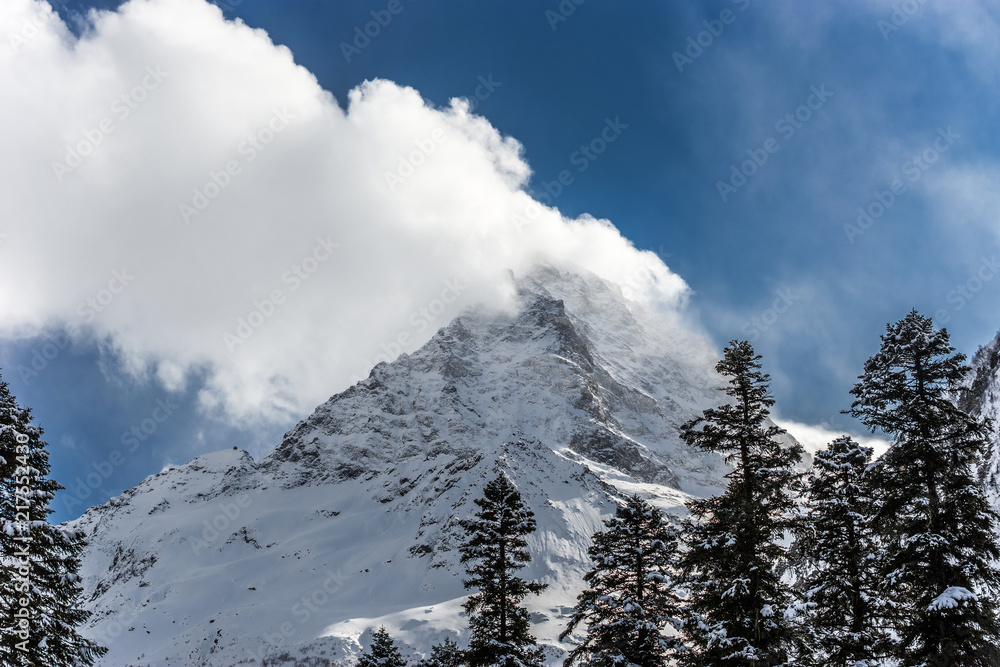 Cloud above Mt. Belalakaya summit in winter day. View from Alibek, Dombay, Russia.