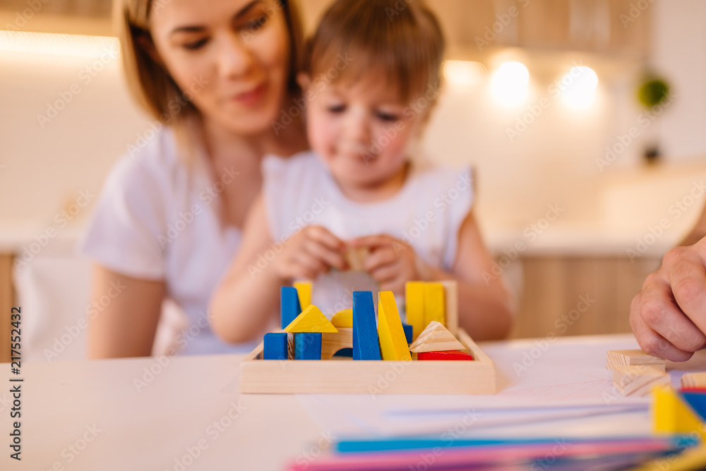 Portrait of mother and her daughter who are playing with toys. Blurred image. Portrait of mother and her daughter who are playing with toys. Blurred image.