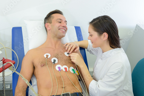 Quadro su tela Nurse attaching heart monitor pads to patient
