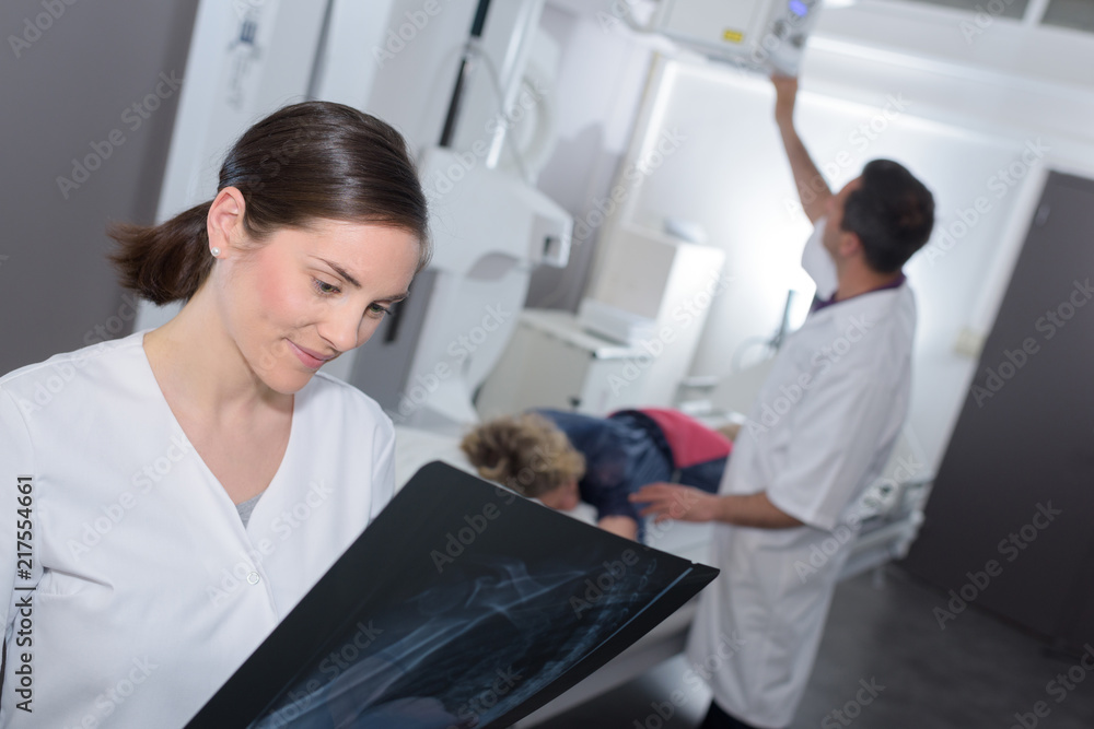 Fototapeta premium woman doctor looking at x-ray radiography in clinic