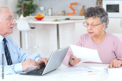 elderly lady dictating letter for husband to type on laptop