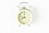 Closeup top view alarm clock on white bed in bedroom for wake up time concept
