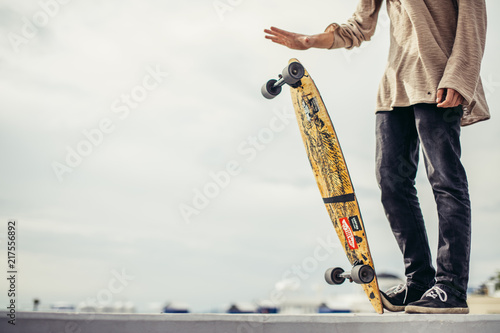 Close up of man foots riding longboard in park photo
