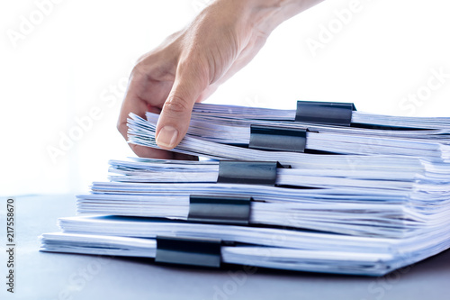 Office documentation in the hands of a woman. Stacks documents files with black clip.