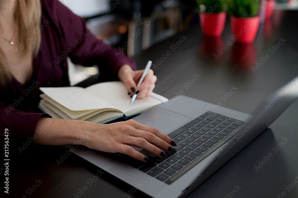 Female hand writing on notebook using pencil writing notebook at coffee shop. Request for online search in Internet writing notes in a notebook using modern netbook computer connected to wireless. Female hand writing on notebook using pencil writing notebook at coffee shop. Request for online search in Internet writing notes in a notebook using modern netbook computer connected to wireless.