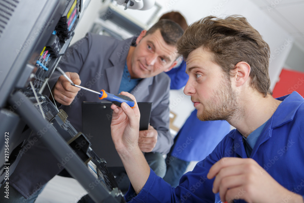 Technicians working on photocopier Technicians working on photocopier