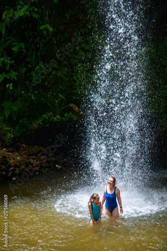 Family swimming in waterfall