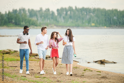 Multiethnic young people having their leisure time on the nature. They walking on the beach