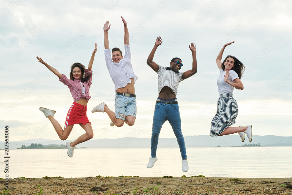 Happy teenagers jumping on the seaside and having fun Happy teenagers jumping on the seaside and having fun