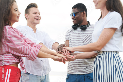 Group of young friends standing and holding hands, they supporting each other