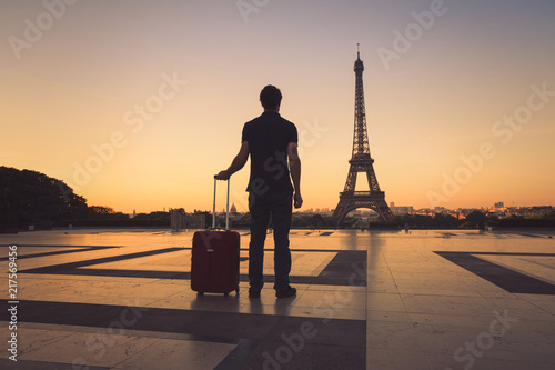 tourist in Paris looking at Eiffel Tower, silhouette of man with luggage travel to France