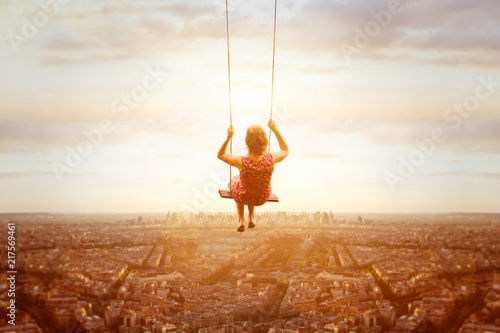happiness and freedom concept, happy romantic beautiful young girl on the swing above the city landscape, cityscape at sunset, dream, joy and inspiration, inspiring life