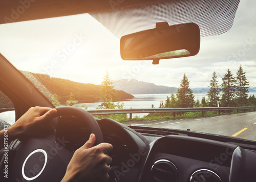 Photo driving car in Norway, roadtrip, hands of driver on steering wheel