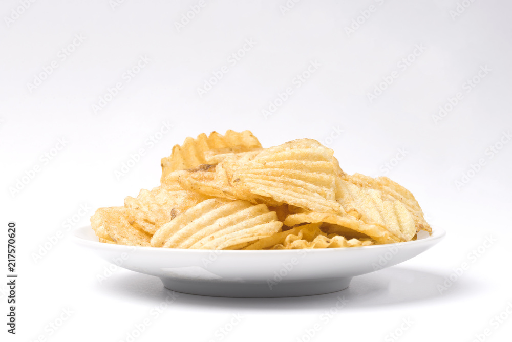 Potato chips in a white saucer on a white isolated background. Chips. Potato chips in a white saucer on a white isolated background. Chips.