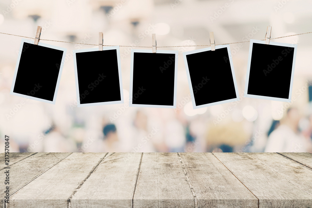 Empty wood table and instant photo hanging on blur image background of people display montage for product. - obrazy, fototapety, plakaty 