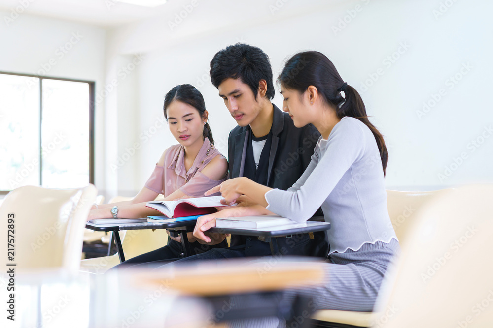Students man and woman reading book preapare for exam highschool in classroom at school. concept of education people learning and tutorial academy. Students man and woman reading book preapare for exam highschool in classroom at school. concept of education people learning and tutorial academy.