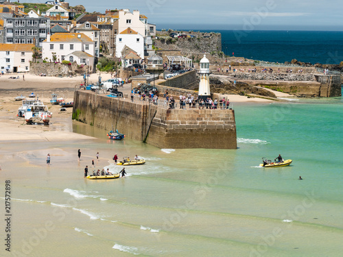 Tourists being taken out to sea on boat trips on a beautiful Summer day in St Ives, Cornwall.