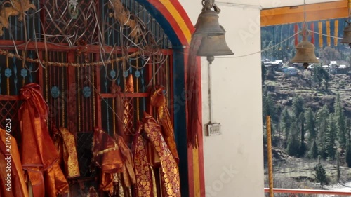 Chapel (datsan) with sacred attributes (silk red canvases and bells) on the background of a beautiful wrought iron lattice. Himalayas, India
 photo