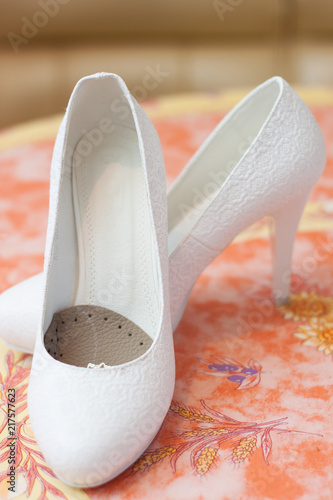 Wedding white female shoes on a colorful blurry background